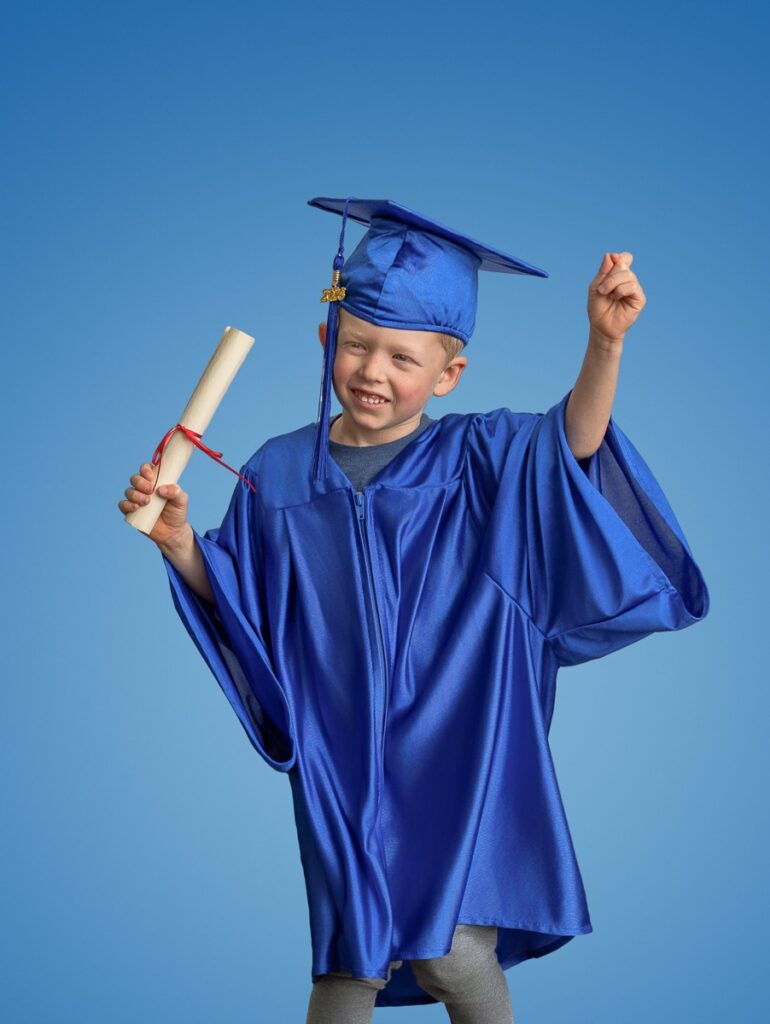Cap and gown preschool graduation portrait of a boy wearing a blue robe  cap and with a gold tassel.