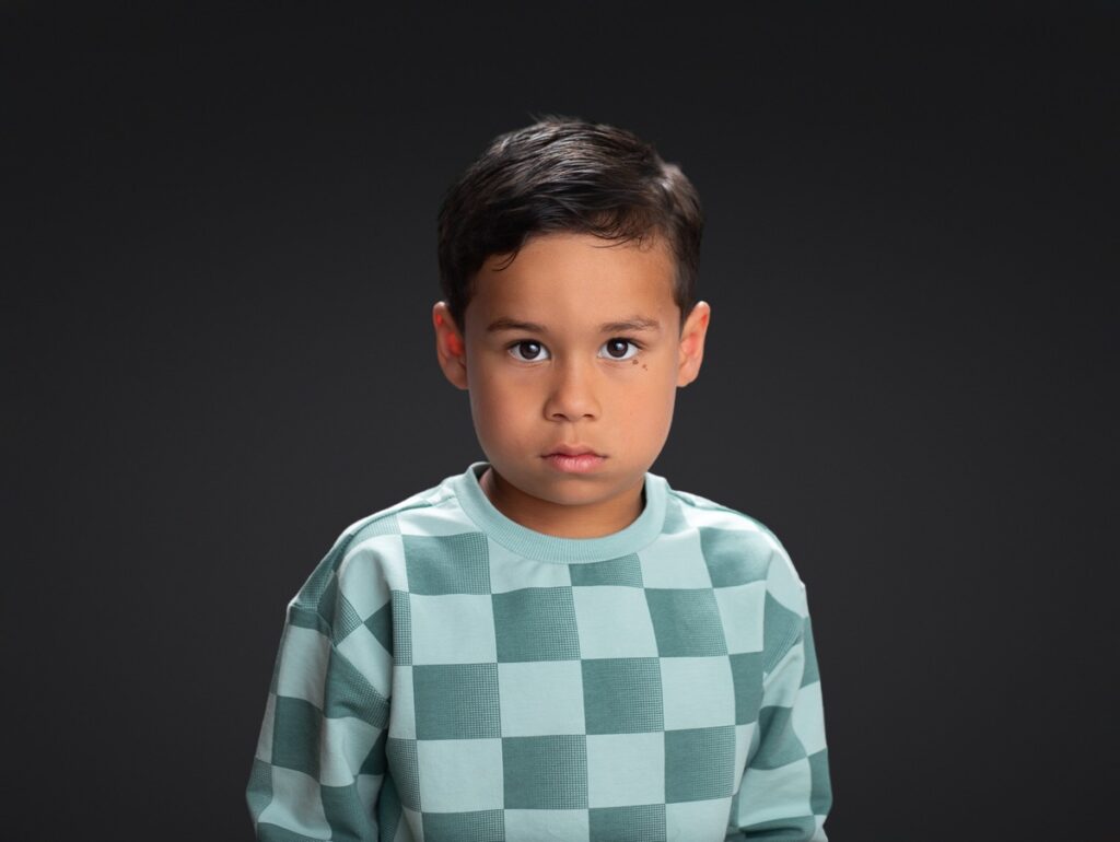 School pictures of preschool boy against a black backdrop by Corinna Black Photography.