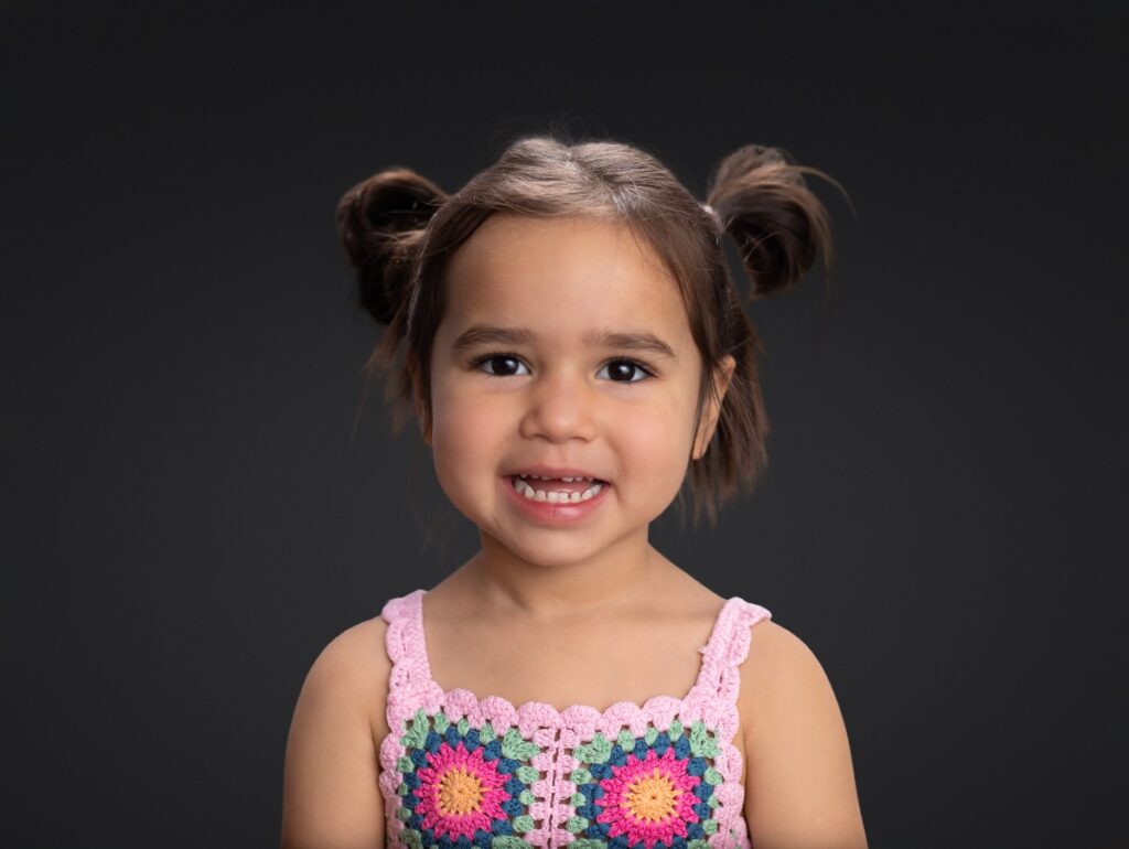School pictures of preschool girl against a black backdrop