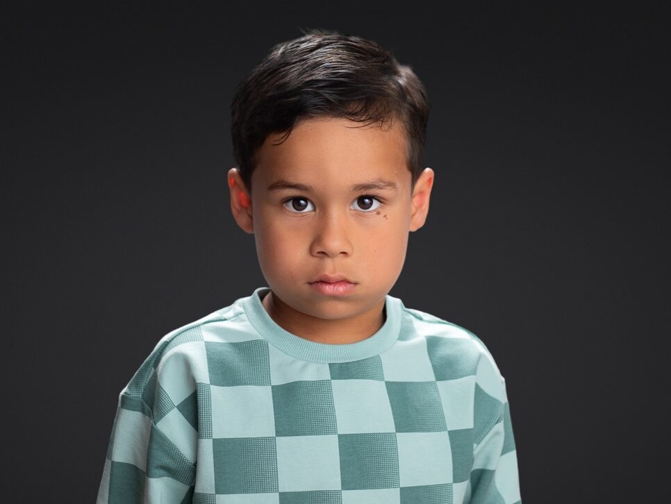 School pictures of preschool student against a black backdrop 